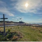A pilgrimage scene - coastline with a cross in the foreground