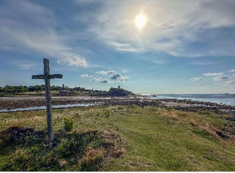 A pilgrimage scene - coastline with a cross in the foreground