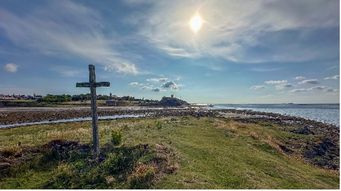 A pilgrimage scene - coastline with a cross in the foreground